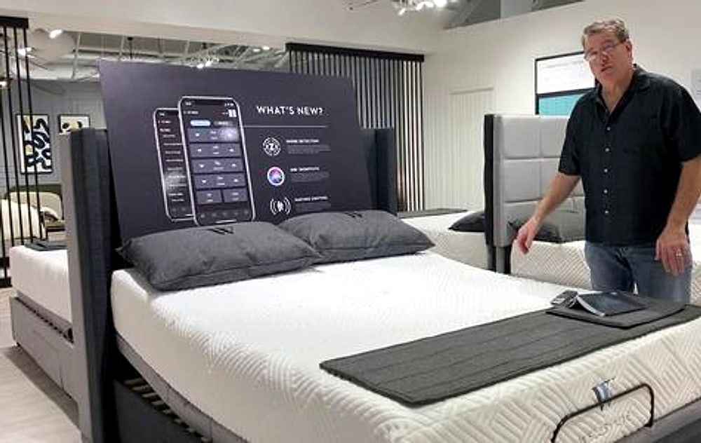 Owner helping a customer choose an adjustable bed in the showroom